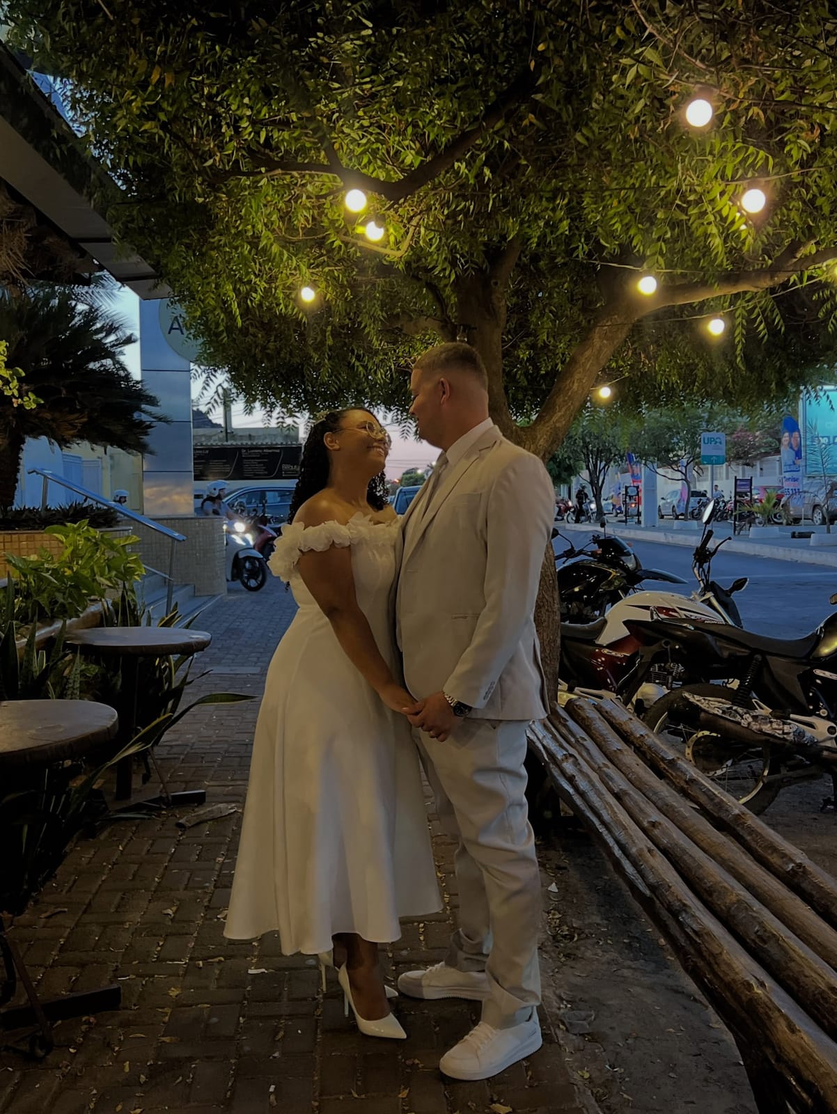 Noivos se olhando sob as luzes da árvore